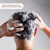 Pessoa lavando o cabelo com espuma branca. Indica: ideal para couro cabeludo oleoso e dermatite seborreica (caspa).