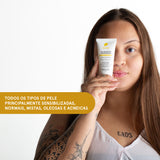 Mulher com tatuagens no braço segura Gel Hidratante Bioreparador. Indica: todos os tipos de pele, inclusive sensibilizadas.
